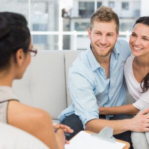 Smiling couple reconciling at therapy session